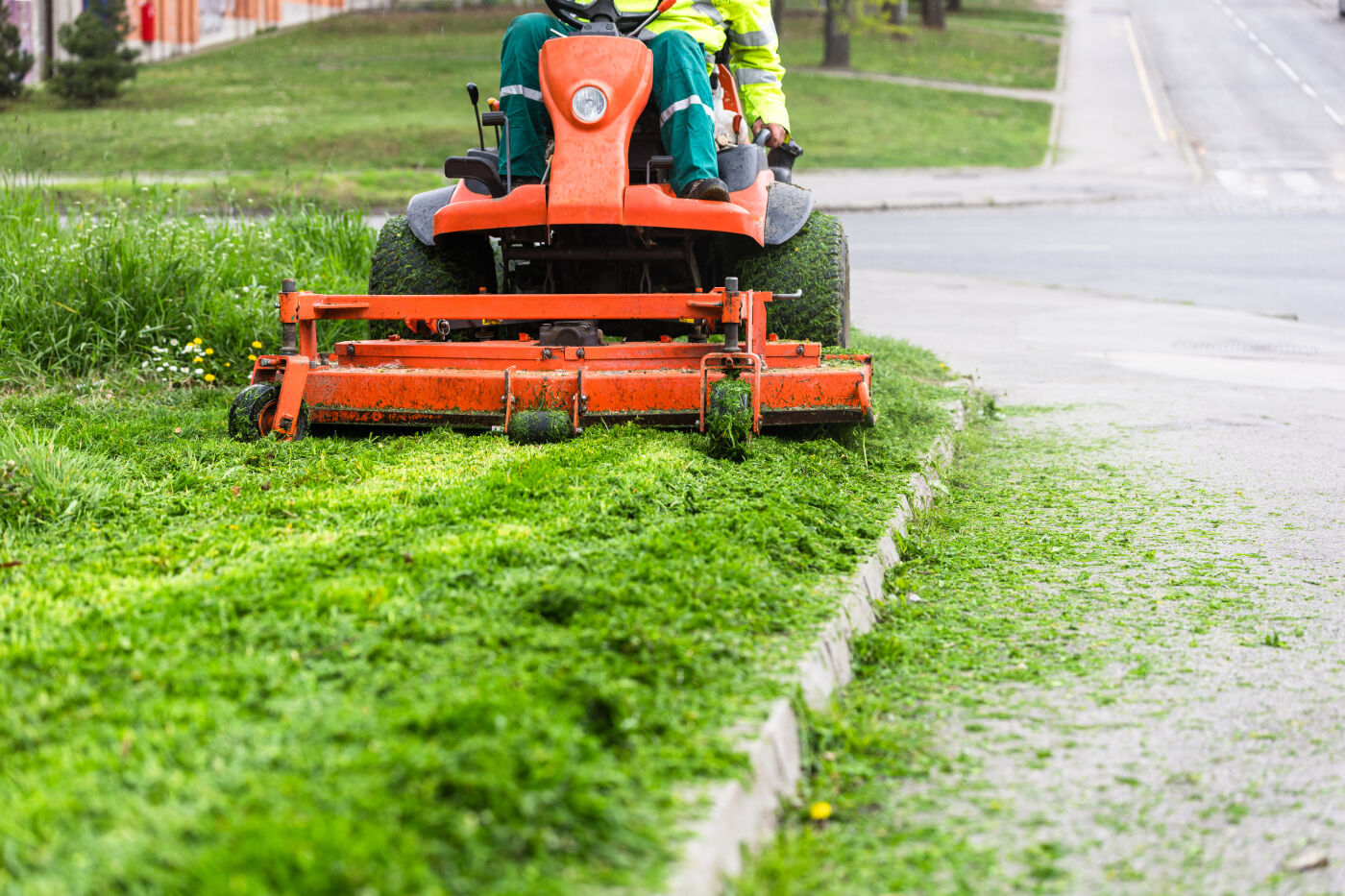 Maaimachinist verantwoordelijk voor het gras die buiten gras maait
